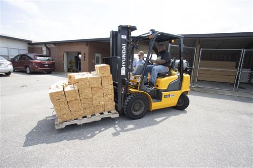 Derricko Sims driving a forklift
